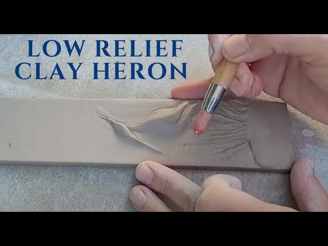 Spontaneous heron in low relief clay sculpture- pottery in the garden